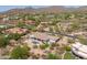 Wide aerial shot of a luxury home in an exclusive community with pool, lush desert landscaping, and distant mountain views at 3946 N Pinnacle Hills Cir, Mesa, AZ 85207
