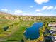 Scenic aerial view showcasing the golf course, lake and the community's luxurious homes nestled in a lush, green landscape at 3946 N Pinnacle Hills Cir, Mesa, AZ 85207