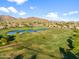Expansive aerial view of the green golf course winding through the beautiful community with scenic mountains in the background at 3946 N Pinnacle Hills Cir, Mesa, AZ 85207