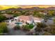 Breathtaking aerial view of a luxury home showcasing a private pool, mountain views, and desert landscaping at sunset at 3946 N Pinnacle Hills Cir, Mesa, AZ 85207
