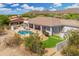 A captivating backyard with a sparkling pool, built-in grill, lounge chairs, and lush desert landscaping at 3946 N Pinnacle Hills Cir, Mesa, AZ 85207