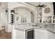 Bar area with white cabinets, marble countertops, wine fridge, and a view to the entry at 3946 N Pinnacle Hills Cir, Mesa, AZ 85207