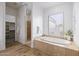 Spa-like bathroom with a soaking tub, walk-in shower, and plenty of natural light, creating a serene retreat at 3946 N Pinnacle Hills Cir, Mesa, AZ 85207