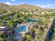 Aerial view of the community pool and tennis courts surrounded by desert scenery at 3946 N Pinnacle Hills Cir, Mesa, AZ 85207