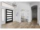 Grand entryway with a modern black front door, wood-look tile flooring, and soaring ceilings, offering a welcoming ambiance at 3946 N Pinnacle Hills Cir, Mesa, AZ 85207