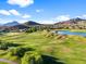 Scenic view of golf course with rolling greens, water features, and desert mountain backdrop at 3946 N Pinnacle Hills Cir, Mesa, AZ 85207