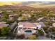 Aerial view showcases home's backyard with pool, spa, and desert landscaping amidst a scenic neighborhood and golf course at 3946 N Pinnacle Hills Cir, Mesa, AZ 85207