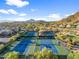 Aerial view of tennis courts and residential houses with desert landscaping at 3946 N Pinnacle Hills Cir, Mesa, AZ 85207