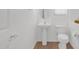 Bright bathroom featuring a pedestal sink, toilet, and tile flooring at 3977 E Cat Balue Dr, Phoenix, AZ 85050