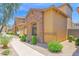Side view of a home with a stone accent wall, manicured landscaping, and a sidewalk at 3977 E Cat Balue Dr, Phoenix, AZ 85050