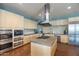 Modern kitchen boasts stainless steel appliances, custom cabinetry, and center island with cooktop at 3977 E Cat Balue Dr, Phoenix, AZ 85050