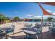 Community pool and patio area offer a relaxing space with tables, chairs, lounge seating and water features under a bright blue sky at 3977 E Cat Balue Dr, Phoenix, AZ 85050