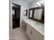 Bright bathroom featuring marble countertop, white vanity, framed mirror, and neutral tile flooring at 4554 E Paradise Village Pkwy # 149, Phoenix, AZ 85032