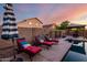 Backyard features chaise lounges, striped umbrella, gazebo, pool, and privacy wall at 46065 W Meadows Ln, Maricopa, AZ 85139