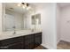 Bathroom boasts double sinks with dark wood cabinetry and a large mirror at 46065 W Meadows Ln, Maricopa, AZ 85139
