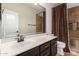 Bathroom with a large mirror, updated sink, and a shower with custom tile detail at 46065 W Meadows Ln, Maricopa, AZ 85139