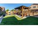 Backyard featuring a gazebo, pool, desert landscaping, and artificial turf at 46065 W Meadows Ln, Maricopa, AZ 85139