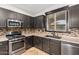 A modern kitchen with stainless steel appliances and earth tone backsplash at 46065 W Meadows Ln, Maricopa, AZ 85139
