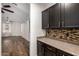 A Butler's pantry with upper and lower black cabinets, and earth tone backsplash at 46065 W Meadows Ln, Maricopa, AZ 85139