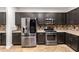 A kitchen with stainless steel appliances and black cabinets at 46065 W Meadows Ln, Maricopa, AZ 85139