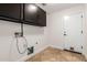 Laundry room with dark cabinets, tile flooring and hookups for machines at 46065 W Meadows Ln, Maricopa, AZ 85139