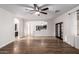 Spacious living room with hardwood floors, tile accent, a ceiling fan, and an archway to the kitchen at 46065 W Meadows Ln, Maricopa, AZ 85139