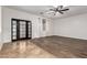 Open living room with hardwood and tile floors, ceiling fan, and access to the outside and other rooms at 46065 W Meadows Ln, Maricopa, AZ 85139