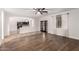 Open-concept living area with wood floors, tile transition, a ceiling fan, and archway to the kitchen at 46065 W Meadows Ln, Maricopa, AZ 85139