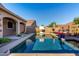 Relaxing backyard pool featuring a basketball hoop, lounge chairs, and a well-manicured patio area at 46065 W Meadows Ln, Maricopa, AZ 85139