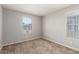 Carpeted bedroom featuring neutral walls, two windows with blinds, and ample natural light at 5812 W Illini St, Phoenix, AZ 85043