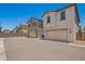 Street view of beige and gray home exterior featuring garages at 5812 W Illini St, Phoenix, AZ 85043