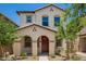 Charming two-story home with a red door, desert landscaping and an arched front entryway at 5812 W Illini St, Phoenix, AZ 85043