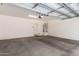 Spacious garage with concrete flooring, overhead lighting, and door at 5812 W Illini St, Phoenix, AZ 85043