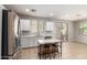 Open kitchen features stainless steel appliances, a center island with bar stools, and sliding glass doors at 5812 W Illini St, Phoenix, AZ 85043