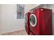 A laundry room featuring modern red washer and dryer units at 5812 W Illini St, Phoenix, AZ 85043