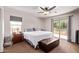 Cozy bedroom featuring a ceiling fan, slider to balcony and large window at 7031 W Lone Tree Trl, Peoria, AZ 85383