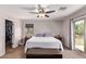 Cozy bedroom featuring a ceiling fan, slider to balcony and walk-in closet at 7031 W Lone Tree Trl, Peoria, AZ 85383