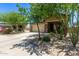Home featuring a two-car garage and desert landscaping that includes trees, bushes, and cacti at 7031 W Lone Tree Trl, Peoria, AZ 85383