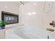 Bright bathroom featuring a soaking tub and a cozy fireplace at 7526 W Cheryl Dr, Peoria, AZ 85345