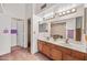 Bathroom featuring double sinks, wood cabinets, and a large mirror at 7526 W Cheryl Dr, Peoria, AZ 85345
