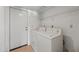 Bright laundry room with white appliances, storage shelf, and access door at 7526 W Cheryl Dr, Peoria, AZ 85345