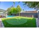 Backyard putting green, swimming pool, palm trees, and black block fence offer relaxation and entertainment at 8119 E San Miguel Ave, Scottsdale, AZ 85250