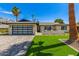Charming home exterior with a modern design, desert landscaping, and an impressive garage door at 8119 E San Miguel Ave, Scottsdale, AZ 85250
