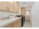 Well-appointed laundry room featuring custom cabinets, stone countertops, modern washer, and stylish tile flooring at 8119 E San Miguel Ave, Scottsdale, AZ 85250