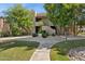 Exterior view of a two-story building with landscaped grounds and mature trees on a sunny day at 9450 E Becker Ln # 2067, Scottsdale, AZ 85260