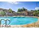 Large community pool with lounge chairs and umbrellas, surrounded by lush landscaping and a clubhouse at 9450 E Becker Ln # 2067, Scottsdale, AZ 85260