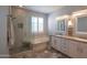 Stylish bathroom featuring a glass-enclosed shower, tub, double vanity, and modern fixtures at 10655 N 9Th St # 112, Phoenix, AZ 85020