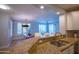 Modern kitchen with granite countertop bar overlooking a dining room and living space with plantation shutters at 10655 N 9Th St # 112, Phoenix, AZ 85020