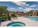 Community pool with lounge chairs, outdoor seating, palm trees, and surrounding townhouses at 10655 N 9Th St # 112, Phoenix, AZ 85020