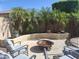 Relaxing backyard features fire pit and ample seating under palm trees at 10773 W Prickly Pear Trl, Peoria, AZ 85383